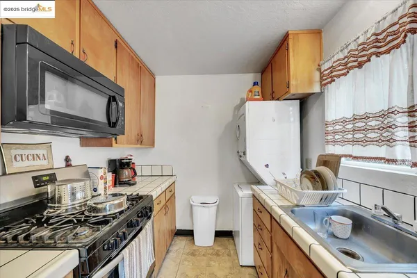 a kitchen with granite countertop a sink a stove and a refrigerator
