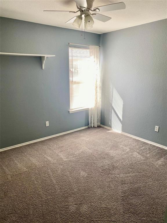 203 Jacinth Lane Granbury, TX 76049 - Photo 16 of 20 an empty room with a window and a chandelier fan