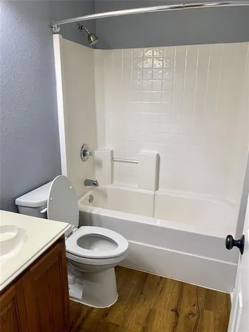 a white toilet sitting next to a bath tub