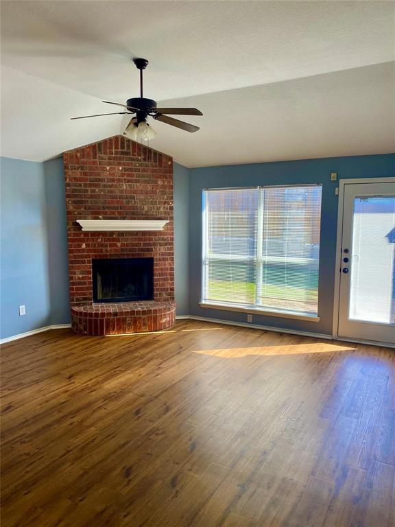 203 Jacinth Lane Granbury, TX 76049 - Photo 8 of 20 a view of an empty room with wooden floor fireplace and a window
