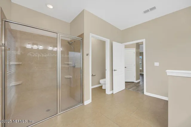 a view of a room with wooden floor and a ceiling fan