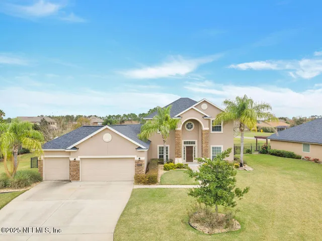 an aerial view of a house with a garden and lake view