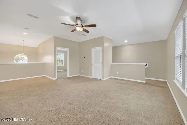 a view of a big room with a ceiling fan and closet area