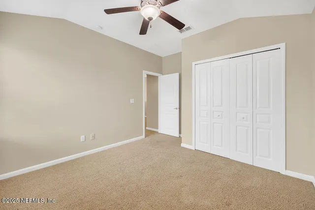 an empty room with a window and a fan