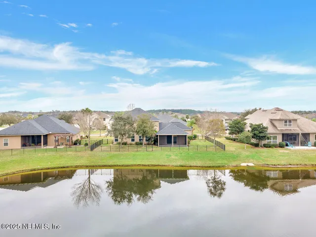 a view of a big house with a big yard and large trees