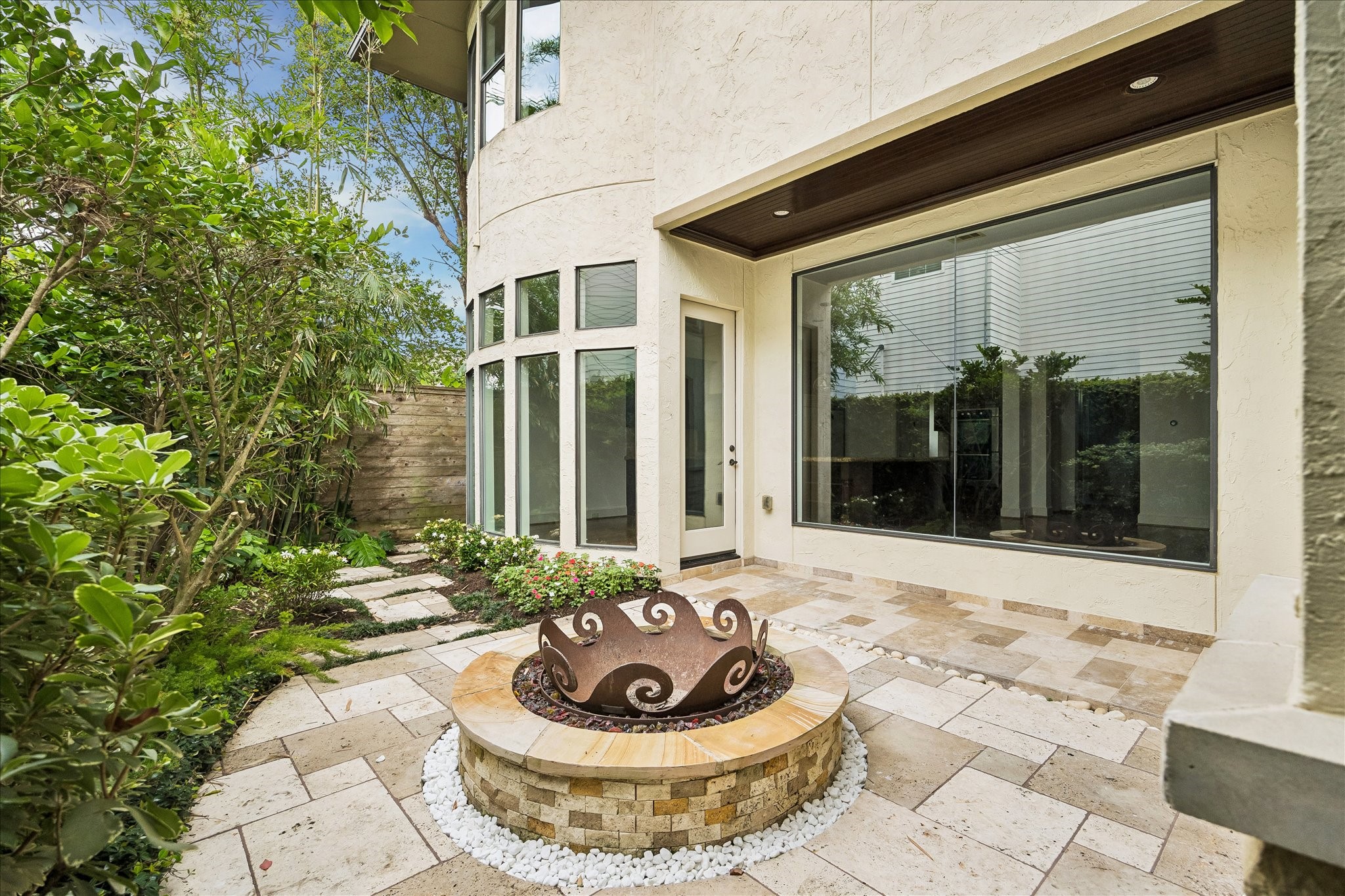 2246 Branard Street Houston, TX 77098 - Photo 21 of 40 Private outdoor retreat featuring manicured landscaping, stone patio, and fire pit focal point.