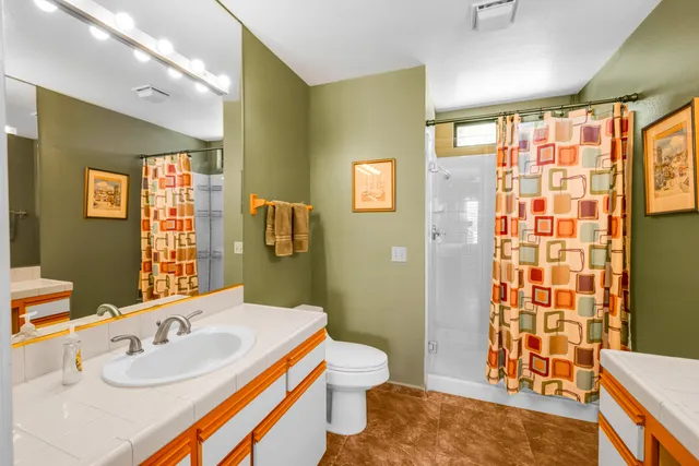 a bathroom with a sink a toilet and shower curtain