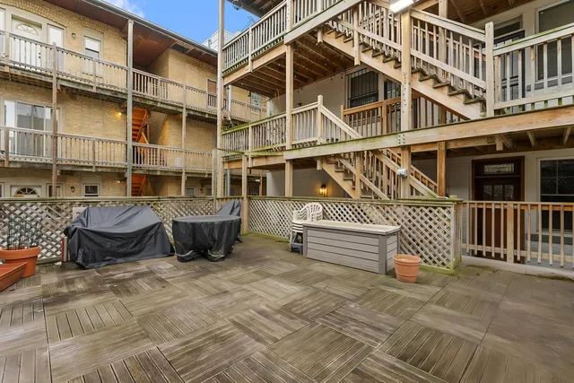 a view of a roof deck with couches and wooden floor