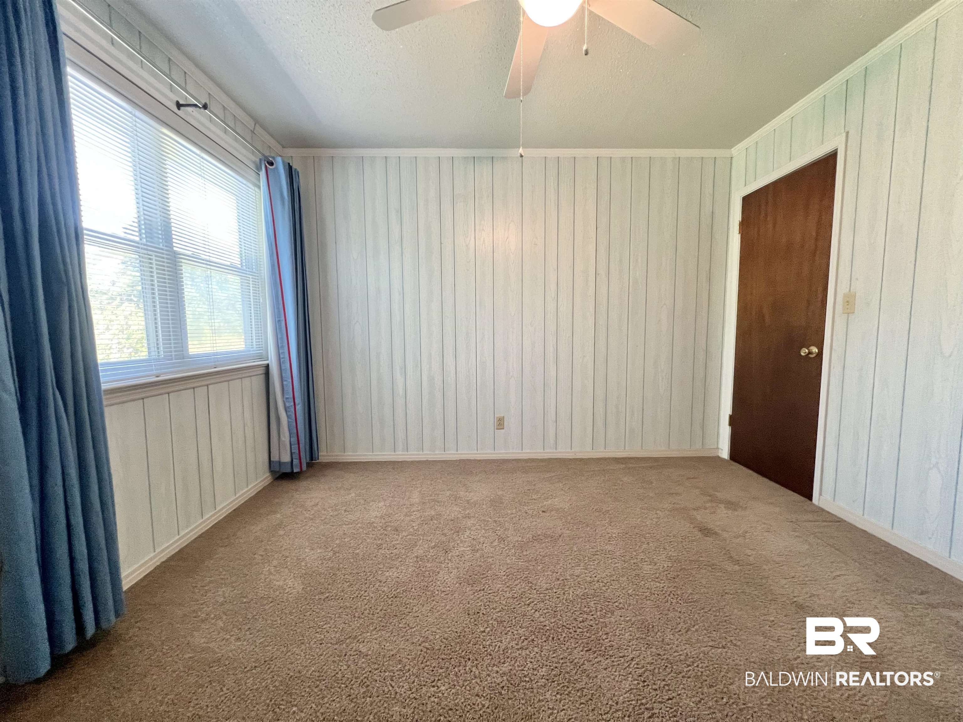 2691 Appleton Road Brewton, AL 36426 - Photo 37 of 60 Carpeted empty room featuring wood walls, a ceiling fan, and ornamental molding