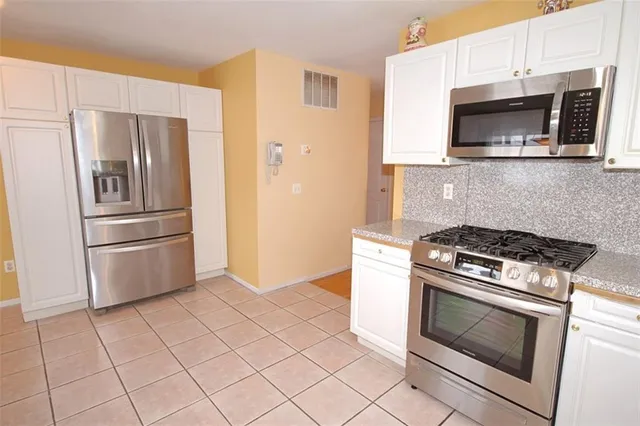 a kitchen with granite countertop a stove and a microwave