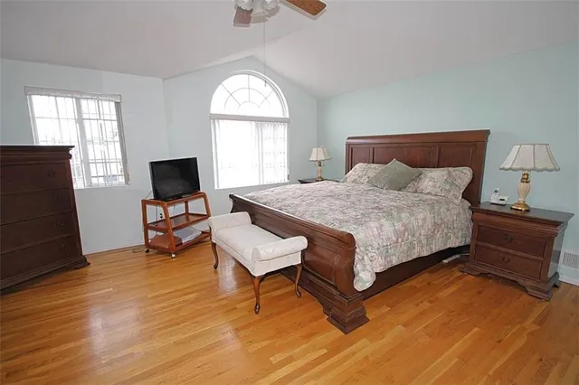 a bedroom with a bed and wooden floor