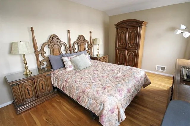 a bedroom with bed and wooden floor