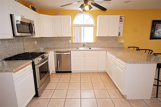 a kitchen with a sink a stove and cabinets