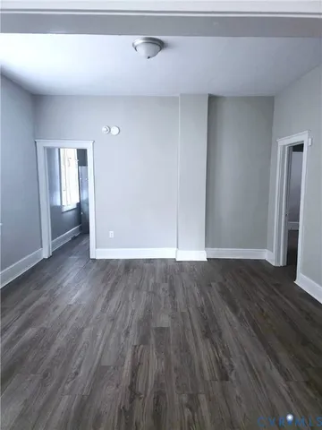 an empty room with wooden floor and closet