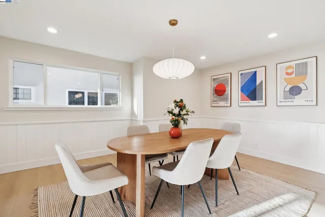 a view of a dining room with furniture a rug and wooden floor