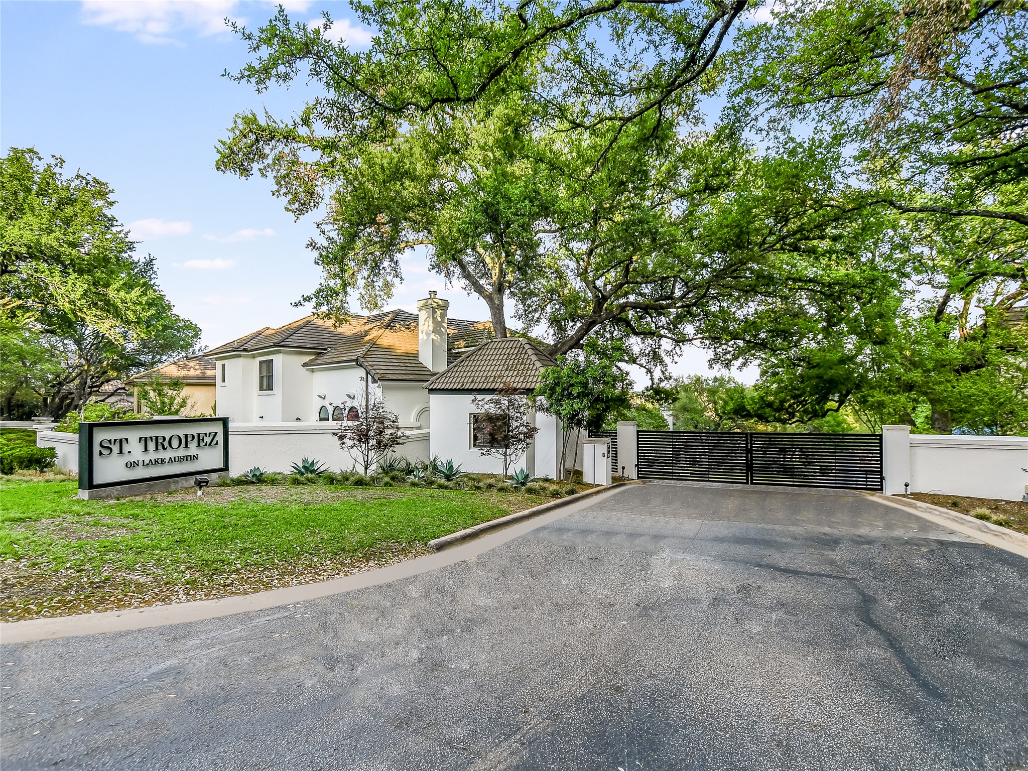 1910 Rue De St Tropez, Unit 4 Austin, TX 78746 - Photo 22 of 36 View of front of property featuring a gate, stucco siding, a chimney, and a tiled roof