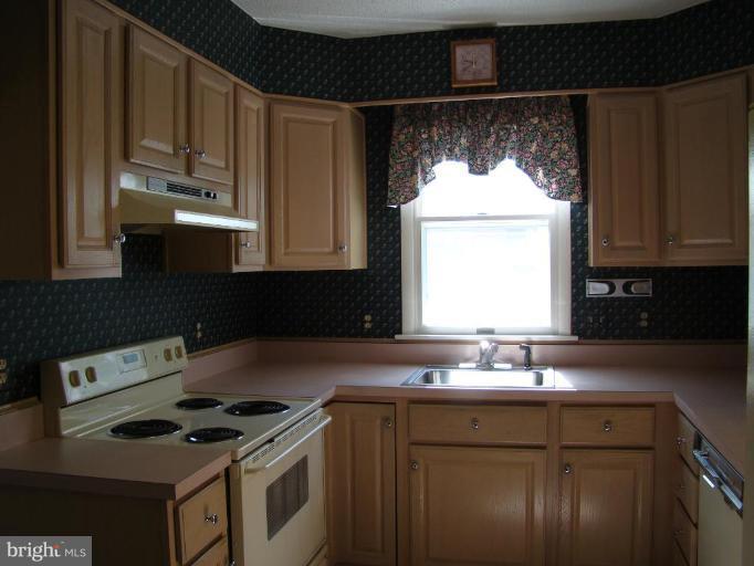 4113 Cliffvale Road Nottingham, MD 21236 - Photo 3 of 8 a kitchen with a sink a stove a microwave and cabinets