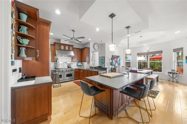 a dining room with stainless steel appliances kitchen island granite countertop a table chairs and a couch