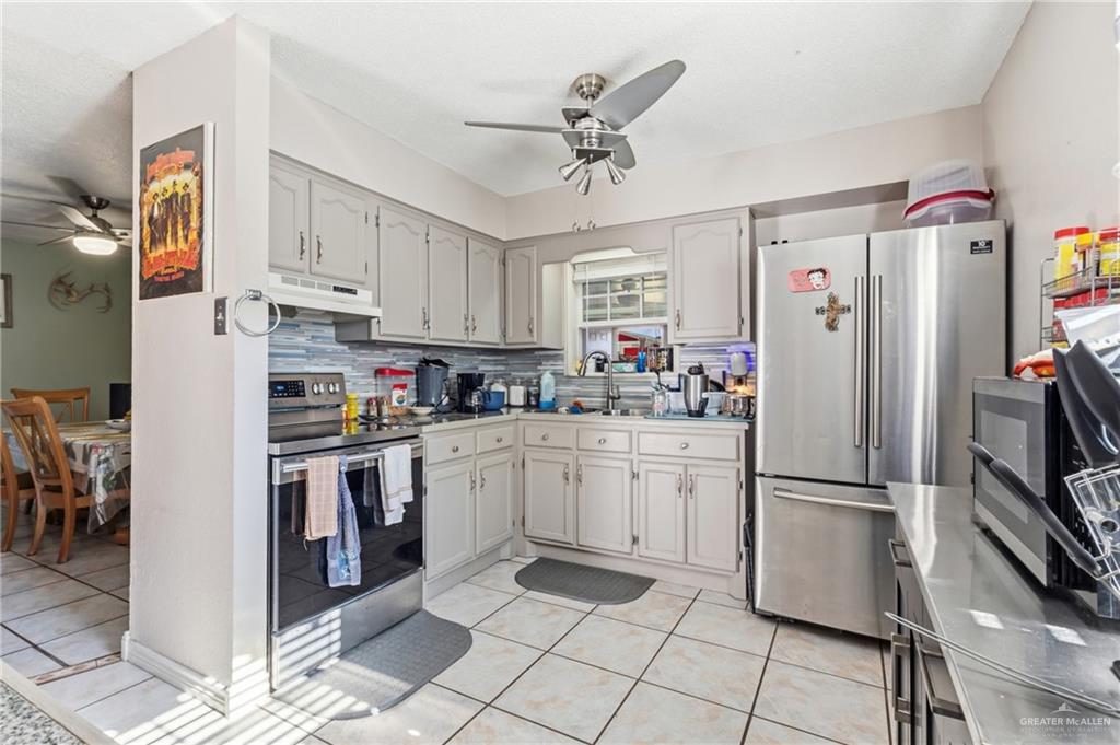 2124 Hawk Avenue McAllen, TX 78504 - Photo 3 of 18 a kitchen with stainless steel appliances granite countertop a refrigerator sink and cabinets