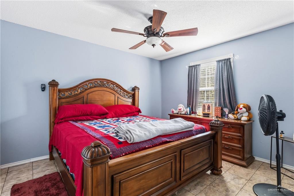 2124 Hawk Avenue McAllen, TX 78504 - Photo 7 of 18 a bedroom with a bed and a chandelier