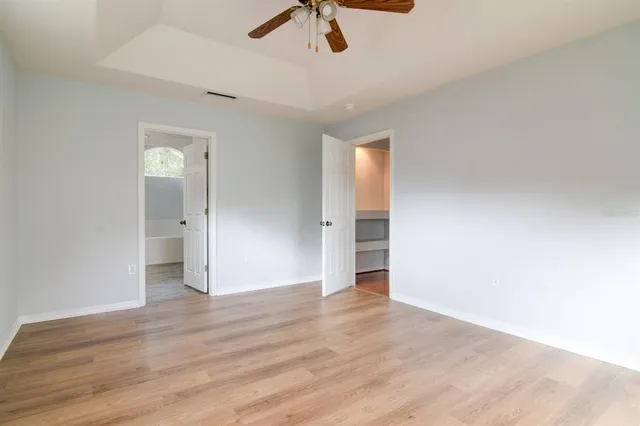 a view of an empty room with window and wooden floor