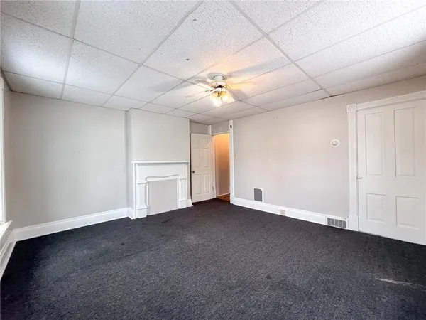 an empty room with a ceiling fan and entryway