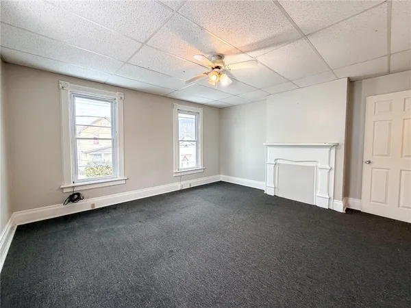 an empty room with windows and fan