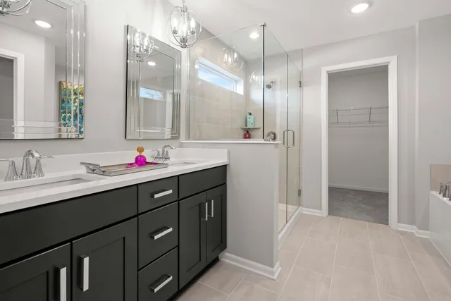 a bathroom with a shower sink vanity and mirror