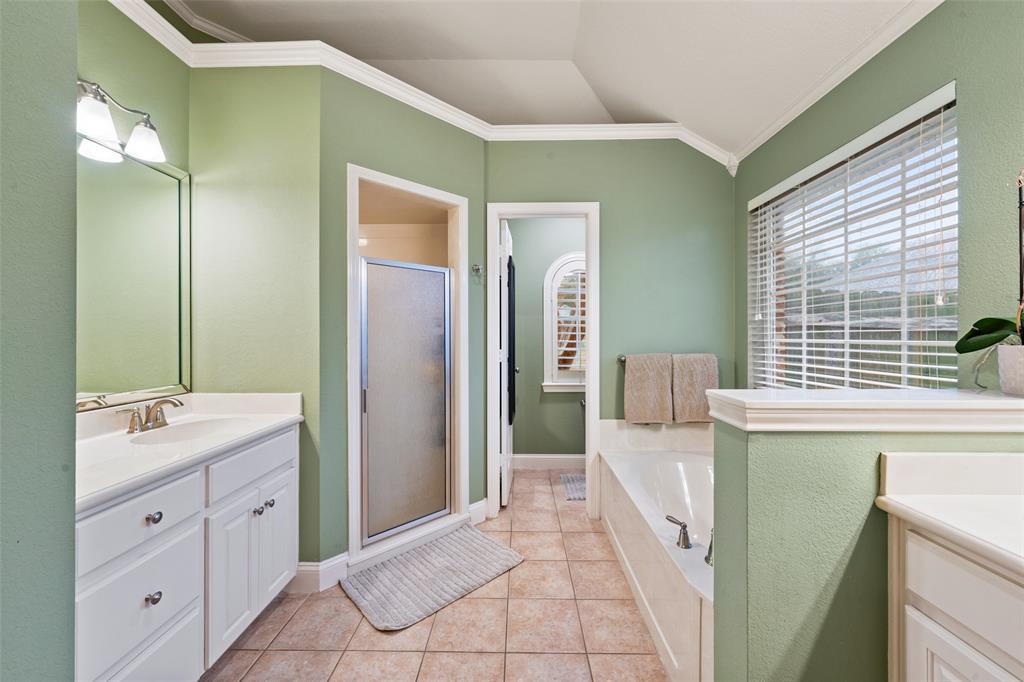 517 Chado Lane Robinson, TX 76706 - Photo 20 of 40 Primary Bathroom featuring ornamental molding, vanity, a garden tub, a shower stall, and light tile patterned floors