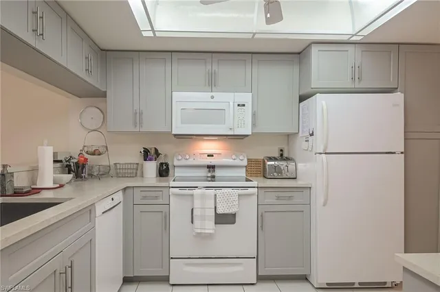 a kitchen with stainless steel appliances granite countertop a refrigerator sink stove and white cabinets