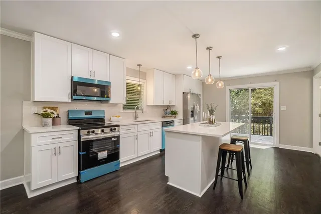 a kitchen with kitchen island granite countertop a sink cabinets and wooden floor