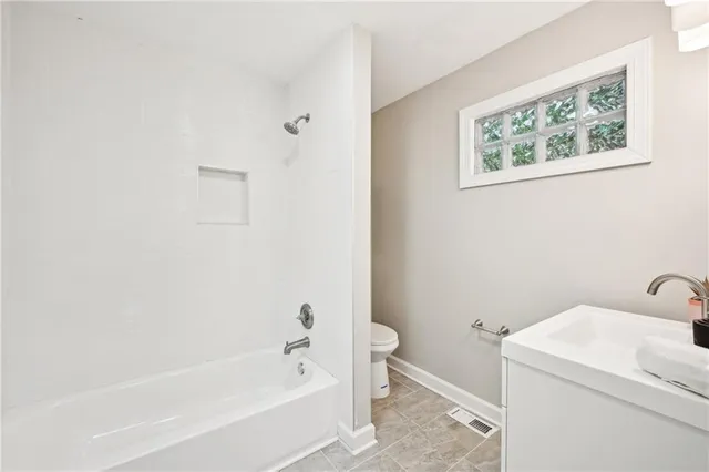 a bathroom with a bathtub and toilet