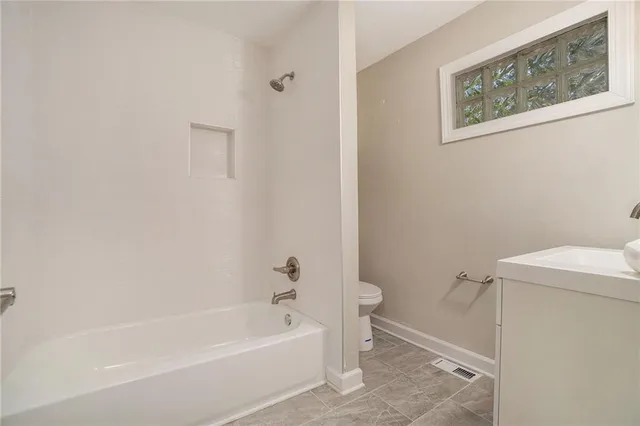 a white bath tub sitting next to a white toilet