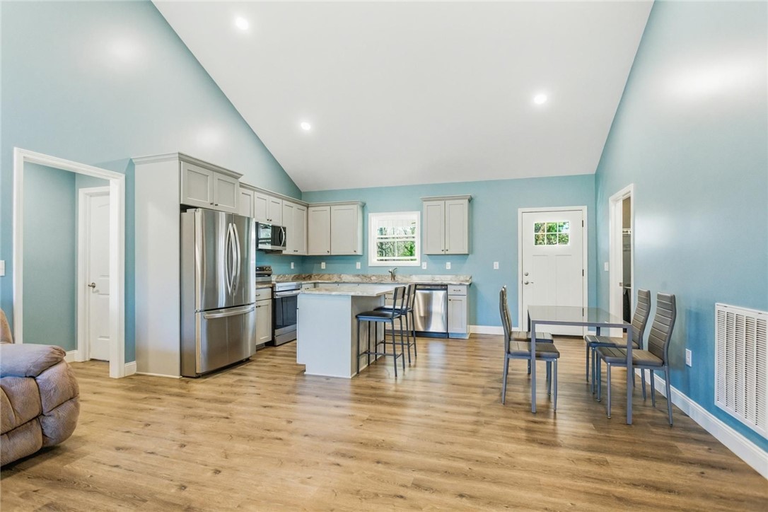 745 Dave Nix Road Seneca, SC 29678 - Photo 10 of 23 A well-appointed kitchen features stainless steel appliances, a center island with seating, and wood flooring throughout.