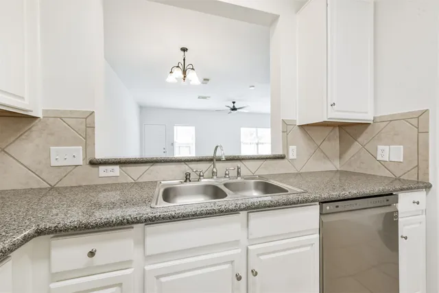 a kitchen with granite countertop a sink and cabinets