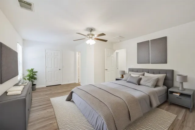 a bedroom with a large bed potted plant and a couch