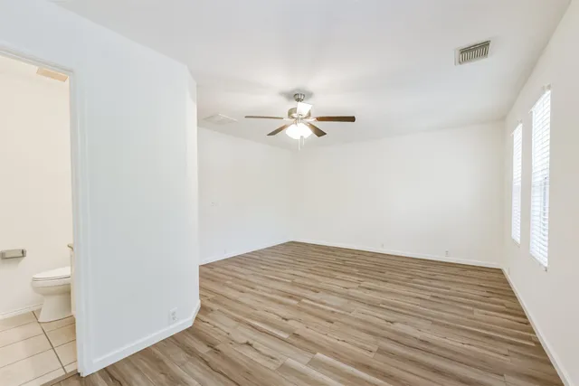 a view of a room with wooden floor and fan