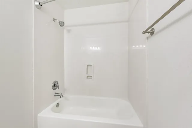 a white bath tub sitting next to a white sink and vanity