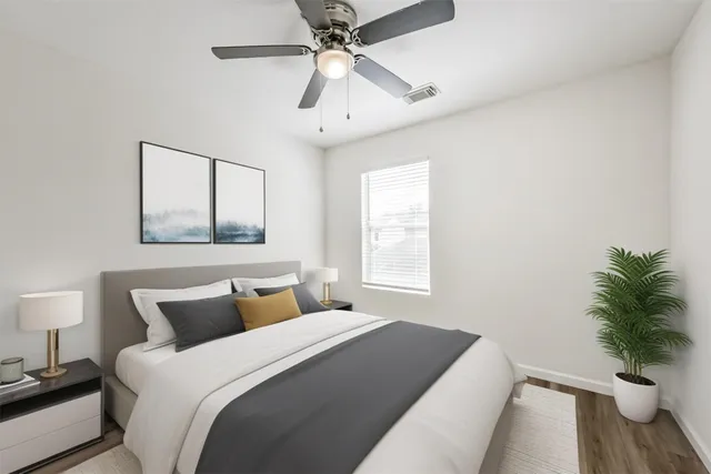 a bedroom with a bed and a potted plant
