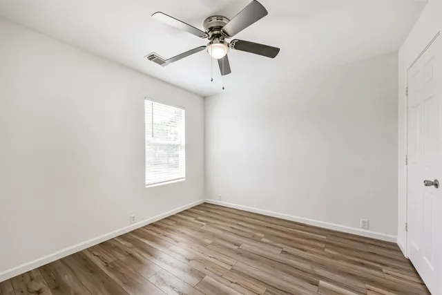 wooden floor in an empty room with a window