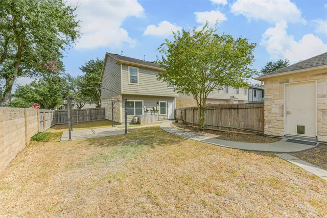 a view of a house with a backyard and a tree