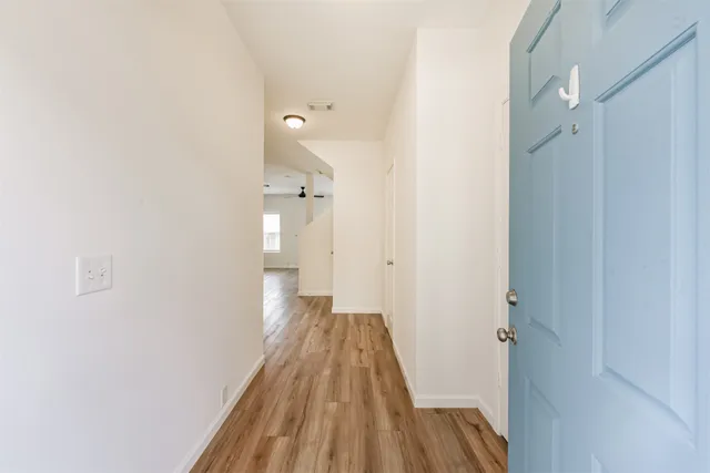 a view of a room with wooden floor and a hallway