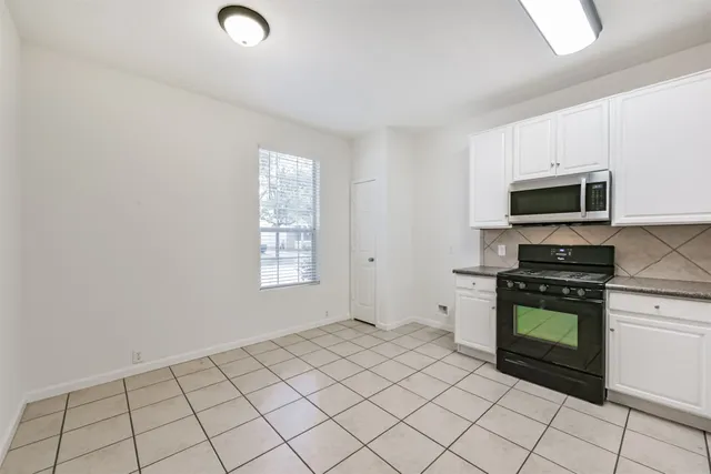 a kitchen with a stove top oven and cabinets