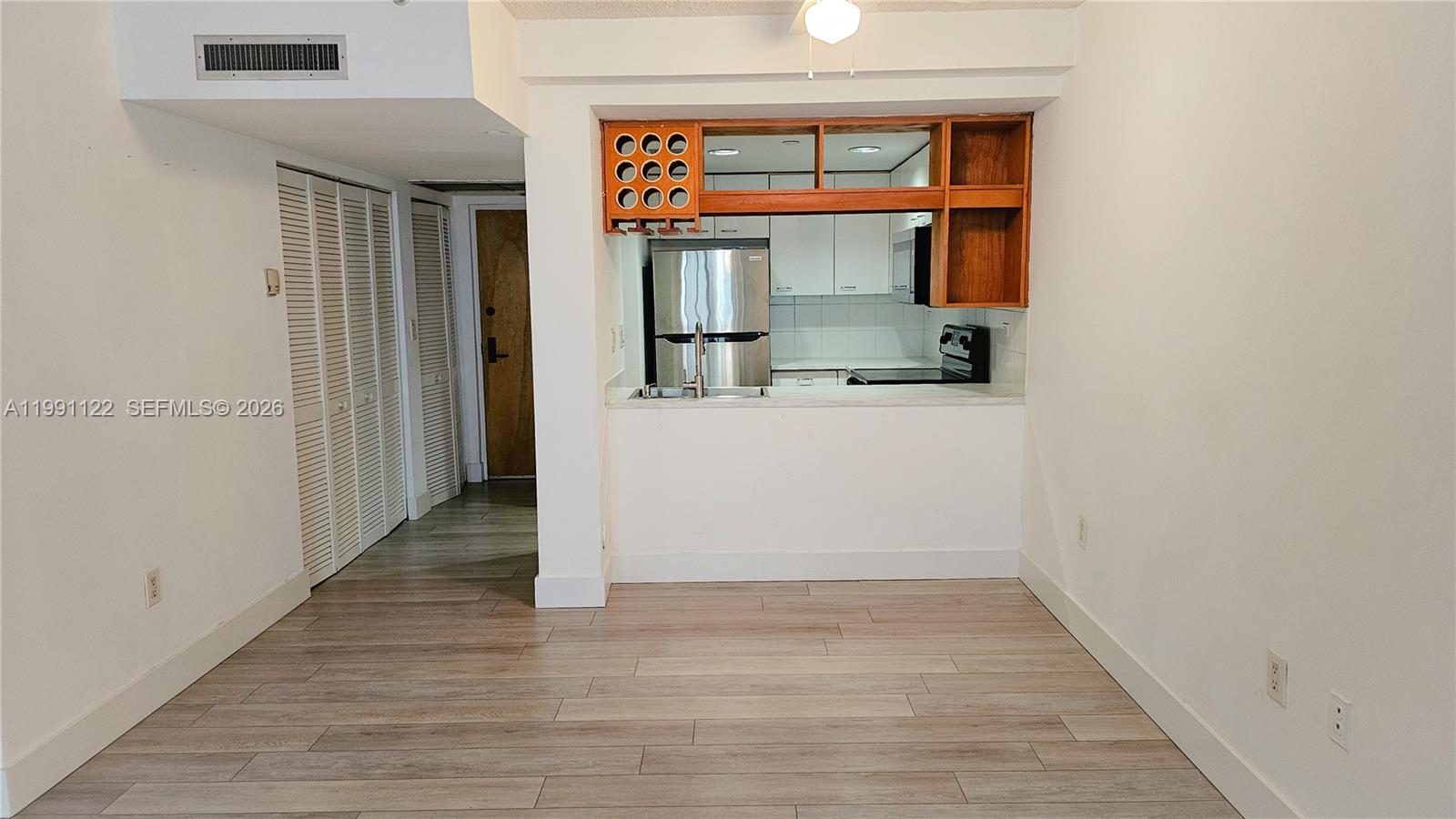 2801 Florida Avenue, Unit 441 Miami, FL 33133 - Photo 6 of 24 an empty room with wooden floor and windows