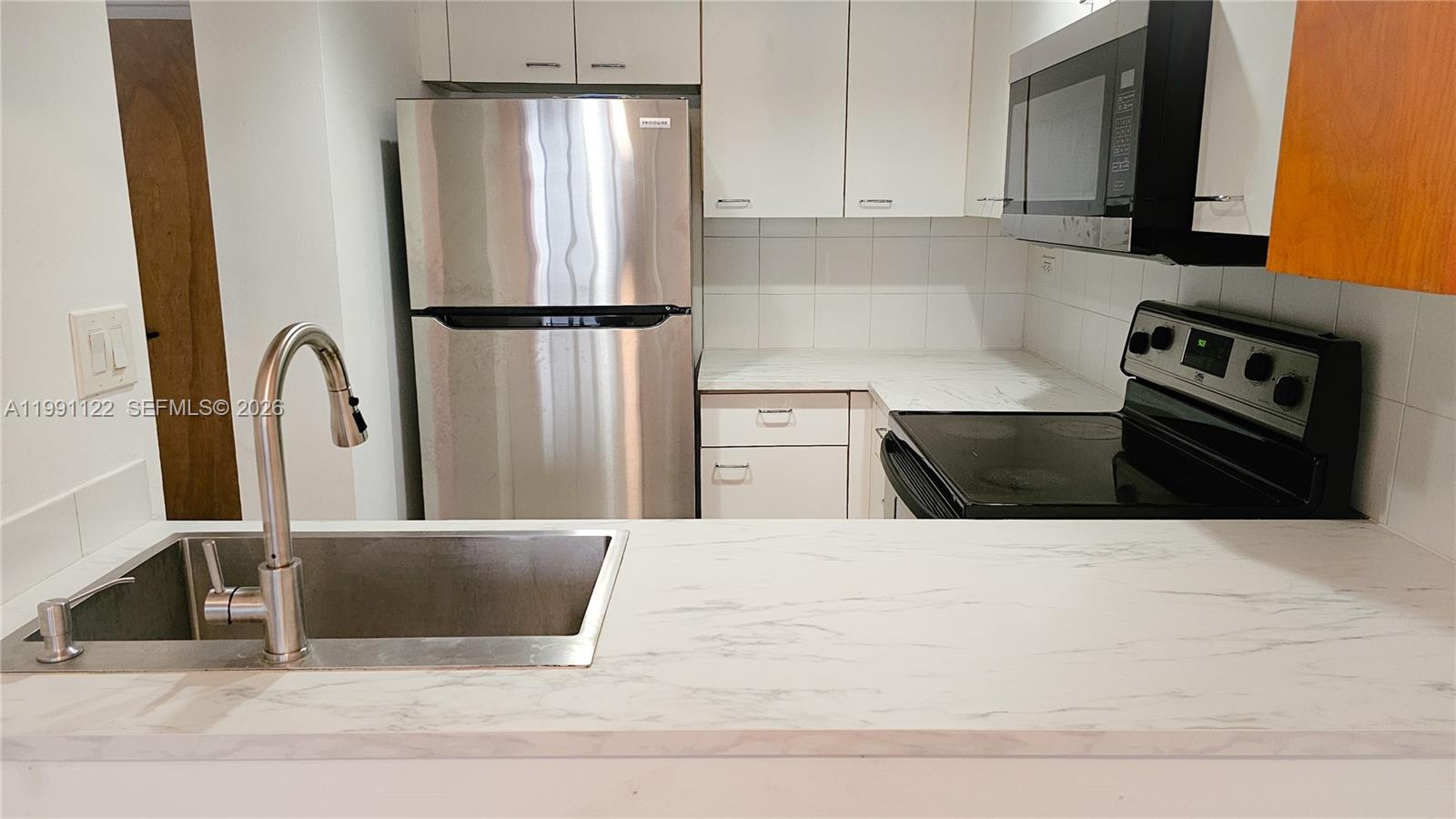 2801 Florida Avenue, Unit 441 Miami, FL 33133 - Photo 8 of 24 a kitchen with stainless steel appliances kitchen island granite countertop a refrigerator a stove and a sink