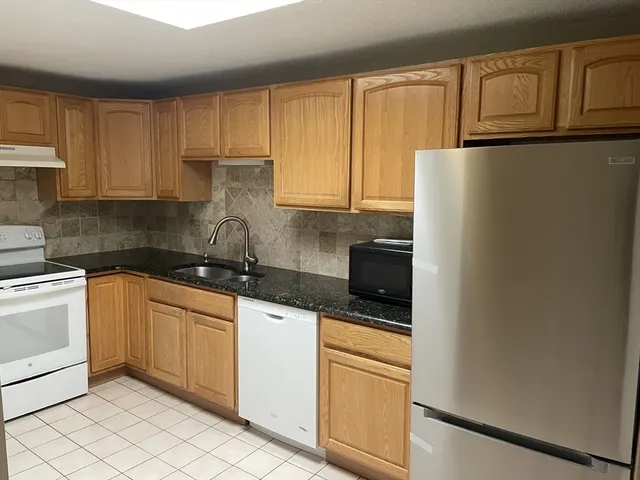 a kitchen with stainless steel appliances granite countertop a refrigerator sink and cabinets
