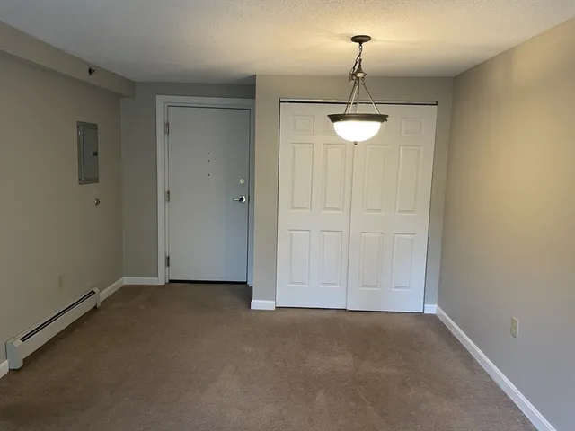 a view of a room with a hanging light and kitchen