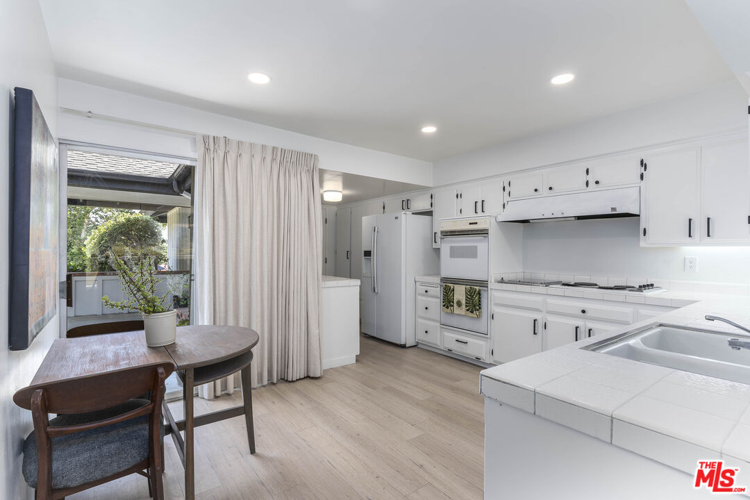 4139 Magna Carta Road Calabasas, CA 91302 - Photo 11 of 33 a kitchen with a refrigerator and a table