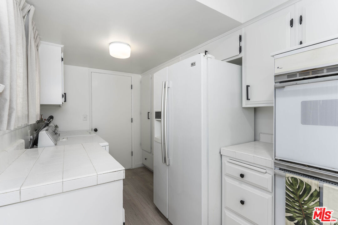 4139 Magna Carta Road Calabasas, CA 91302 - Photo 14 of 33 a kitchen with a refrigerator sink and cabinets
