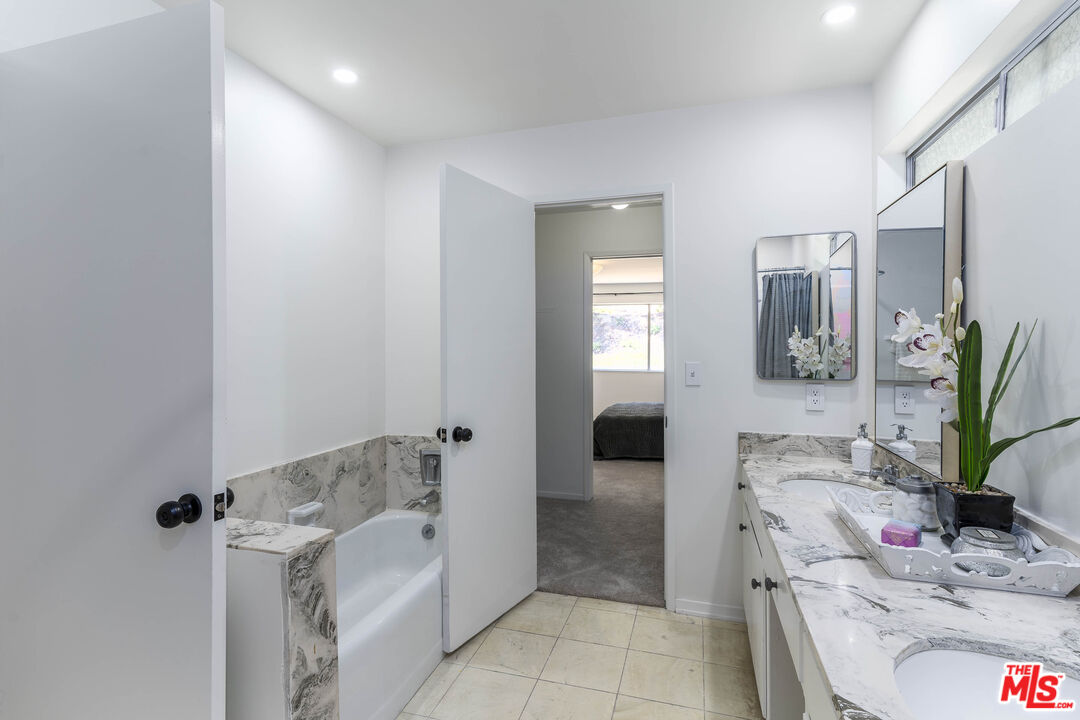 4139 Magna Carta Road Calabasas, CA 91302 - Photo 20 of 33 a bathroom with a tub sink and mirror